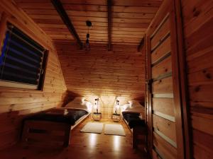 a room with two beds in a wooden cabin at Domki przy plaży in Ryn