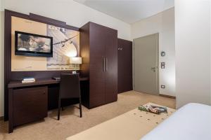 a hotel room with a desk and a bed and a bedroom at Europalace Hotel, BW Signature Collection in Monfalcone