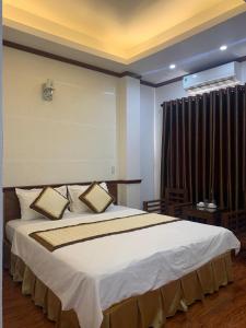 a bedroom with a large bed and a window at Hưng Thành Riverside Hotel in Thái Bình