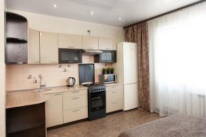 a kitchen with white cabinets and a black appliances at Central Apartament near by Marriott hotel in Novosibirsk