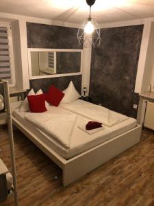 1 dormitorio con 1 cama grande con almohadas rojas en Center Rooms Villach, en Villach