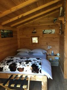 1 dormitorio con 1 cama en una cabaña de madera en la Cabane dans les Arbres en Saint-Jean-dʼAulps