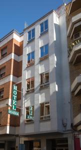 a white building with a sign on the side of it at Hotel Riviera in Córdoba