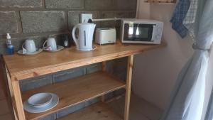 a wooden table with a microwave and a toaster at Cbreeze in Coffee Bay