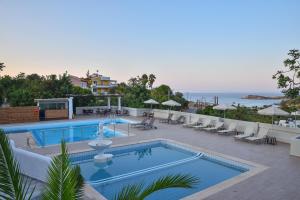 a swimming pool with lounge chairs and a view of the ocean at Bali Mare Village in Balíon