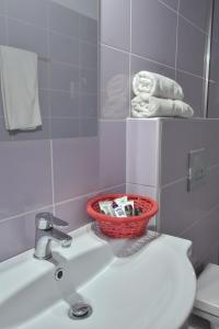 uma casa de banho com uma cesta de produtos de higiene pessoal num lavatório em Bali Mare Village em Balíon