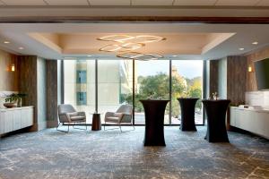 um átrio com mesas e cadeiras e uma grande janela em Kimpton - Hotel Arras, an IHG Hotel em Asheville