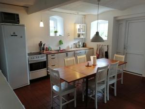 a kitchen with a wooden table and white appliances at Pension Slotsgaarden jels in Jels