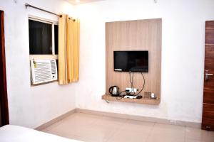 Habitación con TV en la pared en HOTEL UMA PALACE, en Gorakhpur