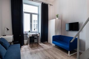 un soggiorno con divano blu e scrivania di Dream Aparts - Piotrkowska 152 a Łódź