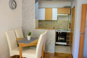 a small kitchen with a table and chairs and a stove at Dunavski Kej in Smederevo