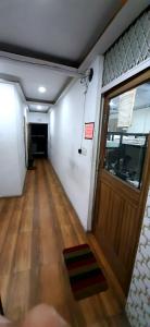 un pasillo vacío con puerta y suelo de madera en Comfort Stay Hostel, en Nueva Delhi