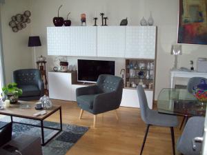 - un salon avec deux chaises et une télévision dans l'établissement T2 avec box proche Graslin, à Nantes