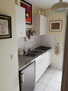 a kitchen with white cabinets and a sink at T2 avec box proche Graslin in Nantes