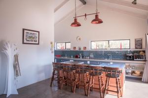 a kitchen with a bar with wooden stools at Rhino Retreat Clarens in Clarens