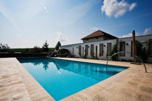 a swimming pool with blue water in front of a building at Country Club La Mesteceni in Sebeş