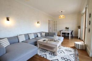 uma sala de estar com um sofá azul e uma mesa em Large 5 rooms with garage in the city center em Annecy