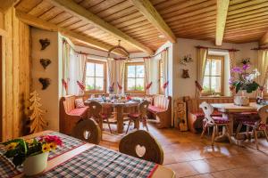 a room with a table and chairs and windows at Agriturismo Maso Grisun in Borzago