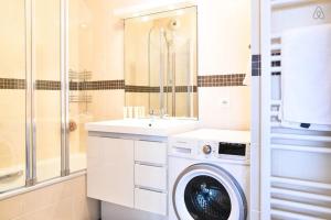 ein Badezimmer mit einer Waschmaschine und einem Waschbecken in der Unterkunft Appartement l'Opale - T2 48m avec parking à 300m du Lac d'Annecy in Annecy
