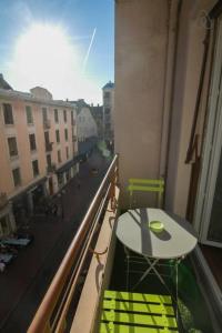 a table and chairs on a balcony with a view of a city at Pretty 3 rooms in the city center in Annecy