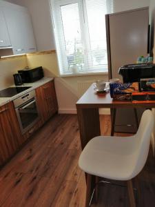 a kitchen with a table and a white chair at Apartament71 in Płock