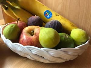 una cesta de frutas con manzanas y plátanos en una mesa en Un Nido Tra Mare e Monti en Partinico