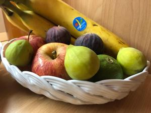 kosz owoców z jabłkami i bananami na stole w obiekcie Un Nido Tra Mare e Monti w mieście Partinico