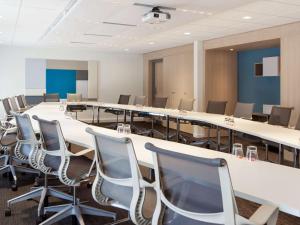a conference room with a long table and chairs at Novotel Massy Palaiseau in Palaiseau
