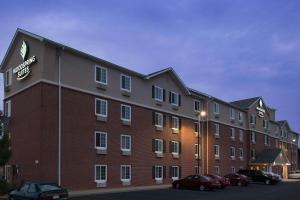 um grande edifício de tijolos com carros estacionados num parque de estacionamento em WoodSpring Suites St Louis Arnold em Arnold