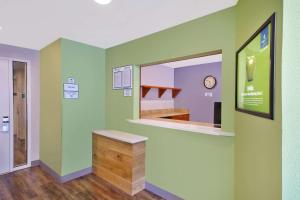 una camera con parete verde, bancone e specchio di WoodSpring Suites St Louis St Charles a St. Charles