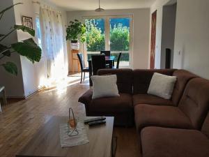uma sala de estar com um sofá castanho e uma mesa em Cozy Villa with a beautiful view em Piatra Neamţ
