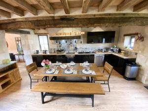 duża kuchnia z drewnianym stołem i krzesłami w obiekcie gite du perche w mieście Bueil