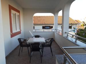 balkon ze stołem i krzesłami w obiekcie Apartments Sunrise w mieście Pirovac