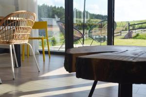 a table and chairs in front of a window at Siedlisko Ciemno in Ciemno