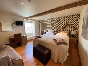 a bedroom with a large bed and a desk at Stay in Westow in Westow