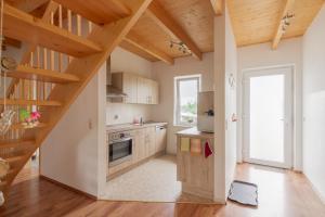 a kitchen with wooden cabinets and a wooden staircase at Ferienhaus Natzel in Darlingerode