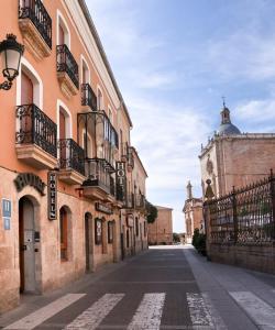 an empty street with buildings and a clock tower at Hotel Arcos Catedral in Ciudad-Rodrigo