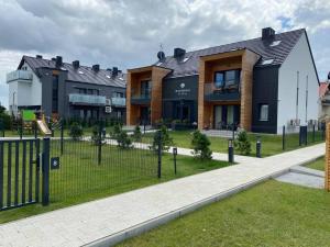 a building with a fence in front of it at APARTAMENT KRYNICA MORSKA in Krynica Morska