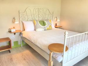 a bedroom with a white bed with a wooden table at The Place in Hengchun South Gate