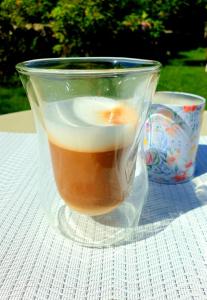 a glass cup of coffee sitting on a table at Casa Altfel in Malaia