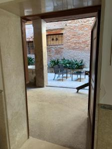 uma porta aberta para um pátio com mesas e cadeiras em Luxury Apartment in San Marco with Canal View em Veneza