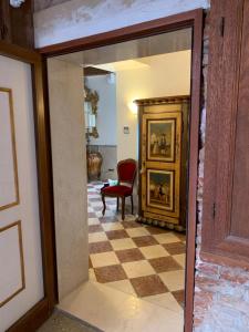 um corredor com um espelho e uma cadeira vermelha num quarto em Luxury Apartment in San Marco with Canal View em Veneza
