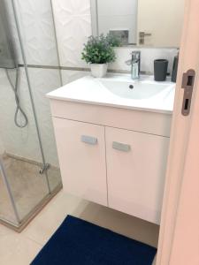 a bathroom with a white sink and a shower at Casa de Oksana in Lagos +96 photos