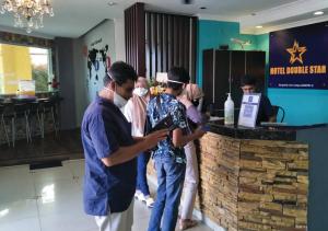 a group of people standing at a counter in a restaurant at Hotel EC Double Star KLIA 1-KLIA 2 in Sepang