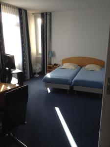 a bedroom with two beds and a television in it at Amadeus Hotel in Sarreguemines