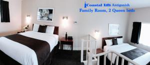 une chambre d'hôtel avec 2 lits et un escalier dans l'établissement Coastal Inn Antigonish, à Antigonish