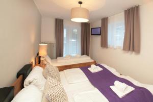 een slaapkamer met een groot bed met witte kussens bij Relaxappartement Wymbs in Zell am See