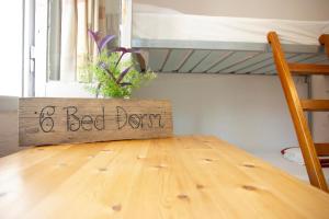 a wooden table with a sign that says bedyden at Himara Hostel in Himare
