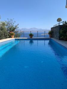 a large blue swimming pool with a view of the water at Villa Muse in Agios Nikolaos