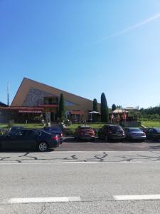 a parking lot with cars parked in front of a building at Restaurant Vi La Maria in Baia de Fier